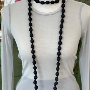 Collar doble de cuentas grandes envueltas en tela negra, exhibido en un busto de tela gris claro.