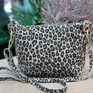 Bolso pequeño con estampado de leopardo en tonos beige y negro, con asa desmontable a juego, sobre una superficie de madera clara.